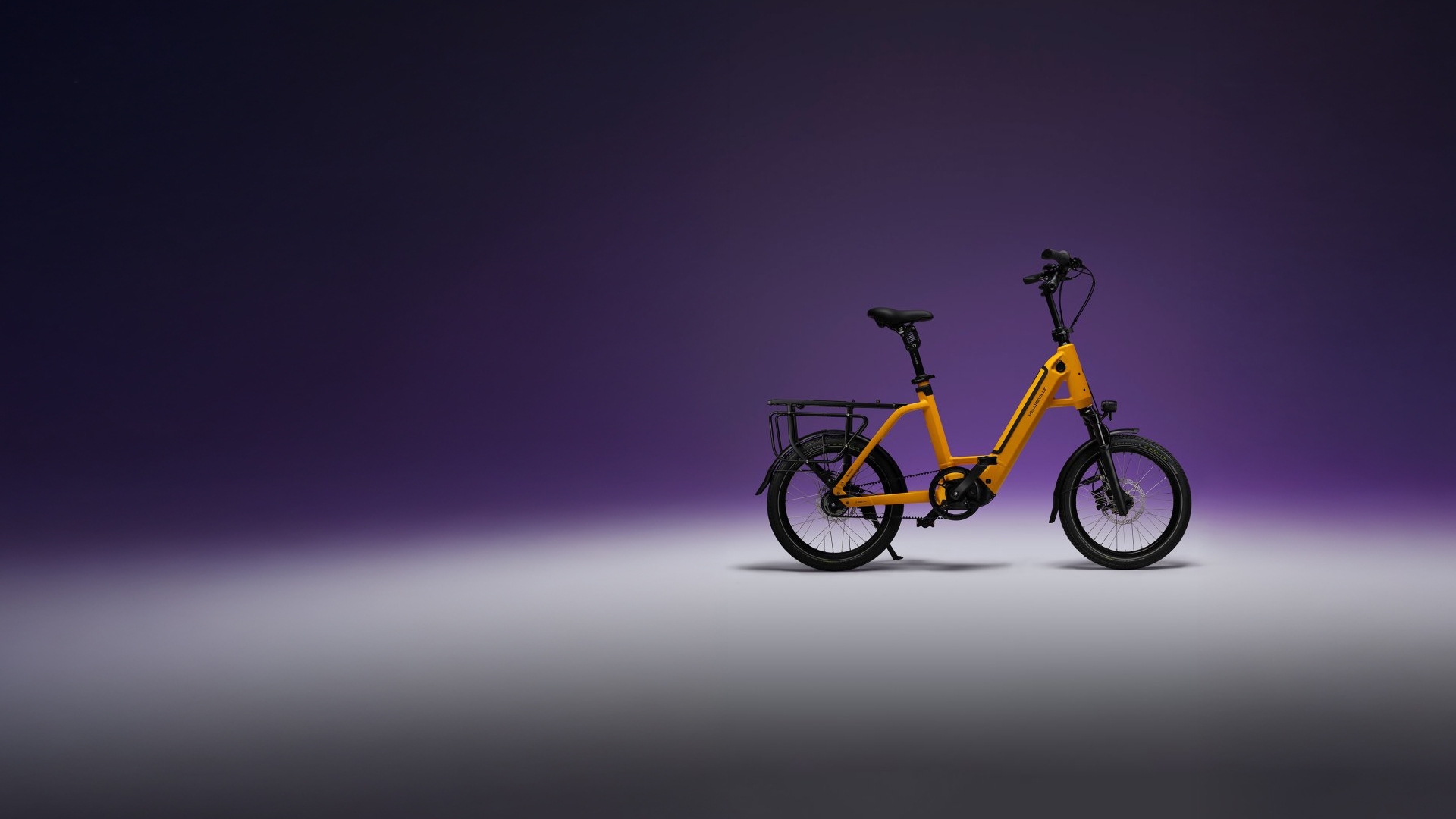 Kompaktes E-Bike vor lila Hintergrund