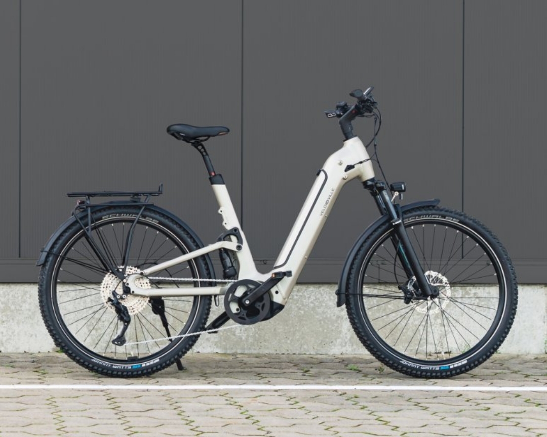 Vollgefedertes E-Bike vor grauer Wand
